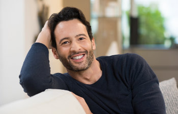 smiling middle aged man sitting on couch