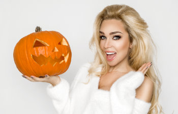 happy beautiful woman holds halloween pumpkin on white background, 