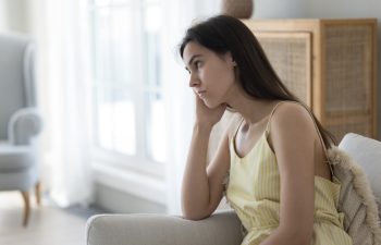 Boring. Sad unhappy tired teen girl sit on couch propping head with hand feel dull spending summer day at home alone suffer from depression loneliness love problems breakup lost in negative thoughts