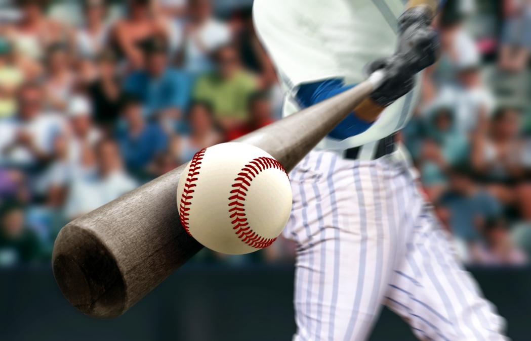 Baseball player hitting ball with bat in close up, 