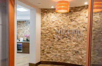 Reception area entrance framed by stacked stone wall and pendant lighting