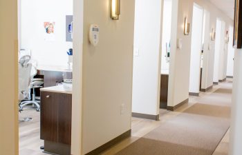 Corridor with treatment room and dental chair visible through doorway