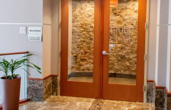 Entrance doors displaying the Muccioli Dental sign and nameplate