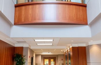 Corridor view showing wood ceiling beam and glass entry doors
